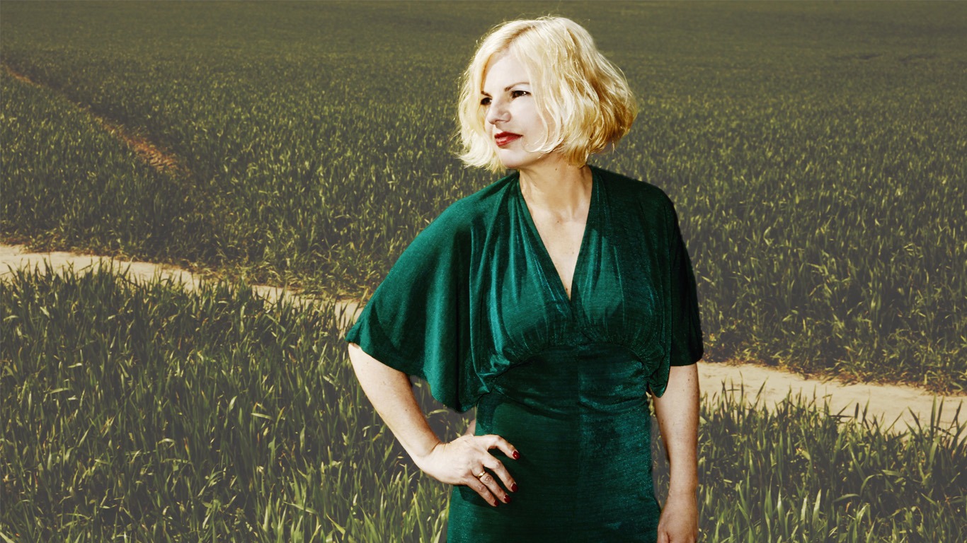 Jessica steht im grünen Kleid auf einem Feld